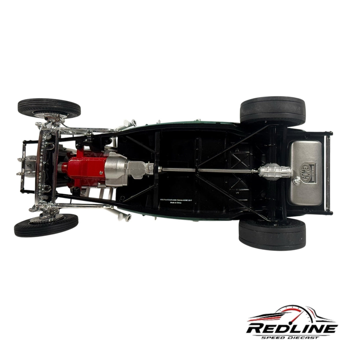 Underside view of a 1932 Ford hot rod diecast model showing the detailed chassis, red engine block, and fuel tank.