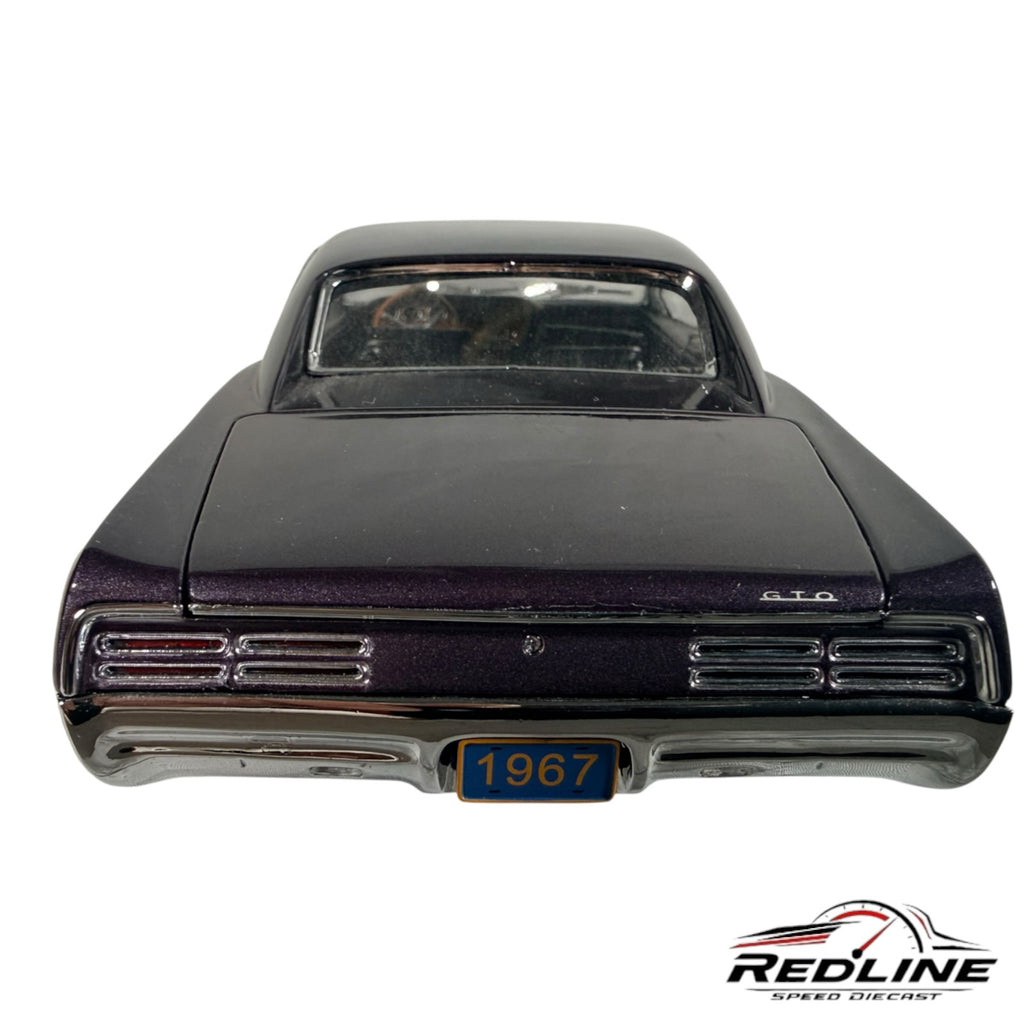 Redline Speed Diecast 1967 Pontiac GTO hardtop model car in dark purple metallic, rear view with 1967 license plate.