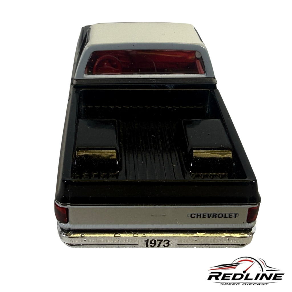 Redline Speed Diecast 1973 Chevrolet C10 pickup truck model in black and silver with a red interior, rear view.