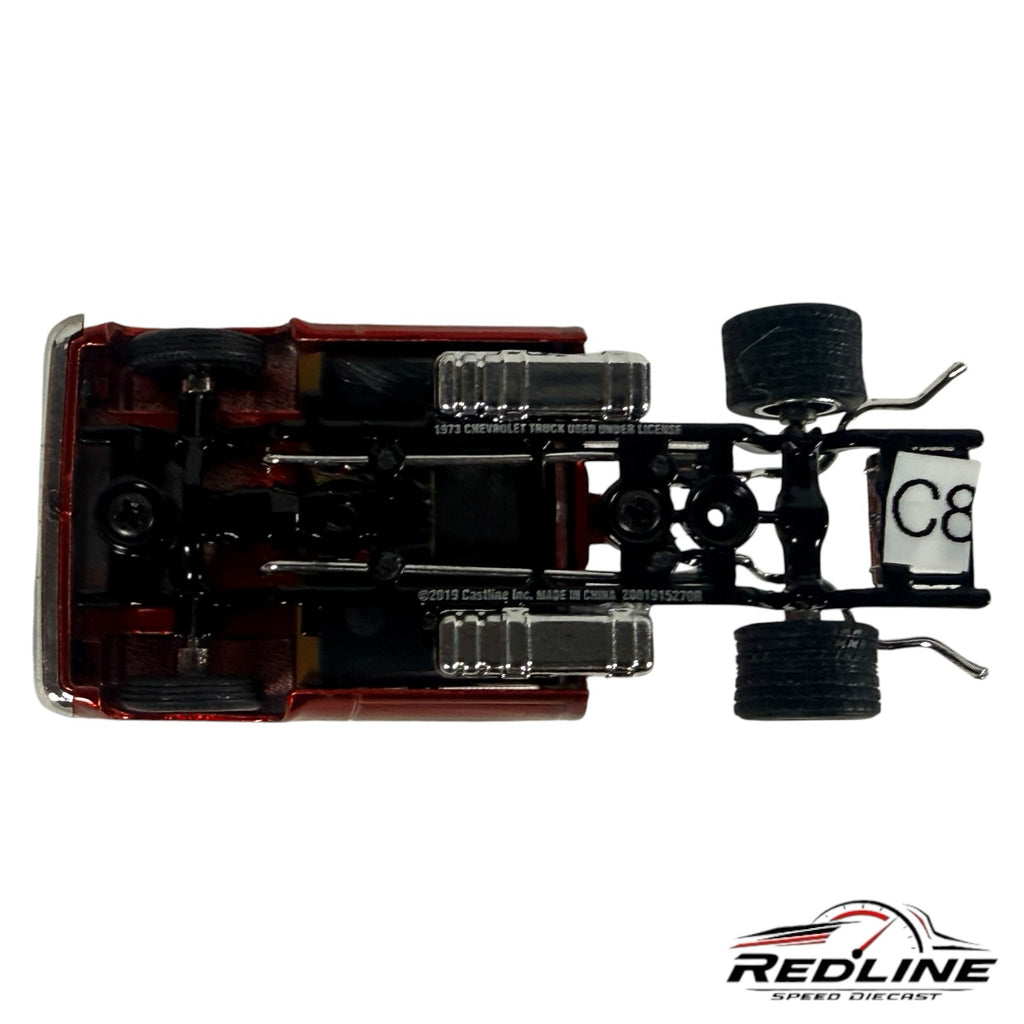 Underside view of a Redline Speed Diecast 1973 Chevrolet Cheyenne model showing the chassis, exhaust, and rear tires.