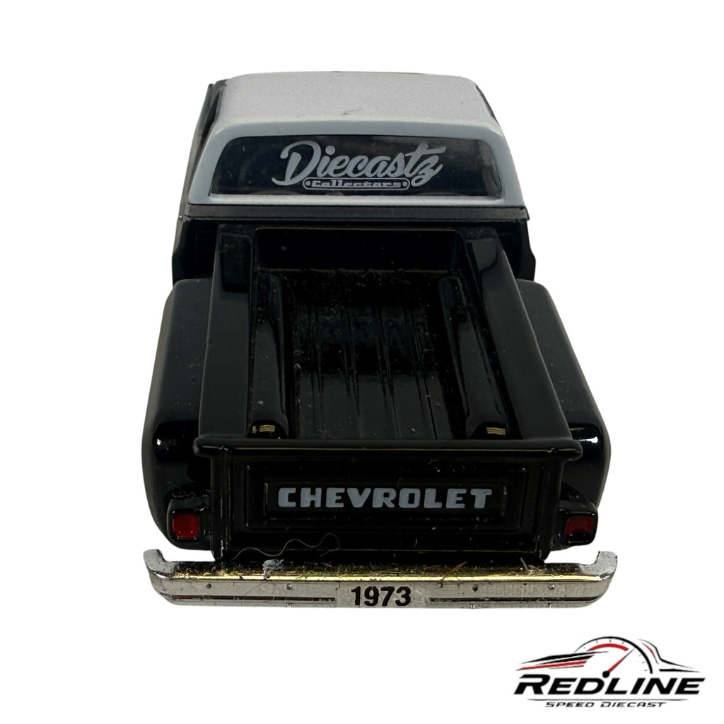 Rear view of a Redline Speed Diecast 1973 Chevrolet Cheyenne 10 model truck with a black and silver finish.