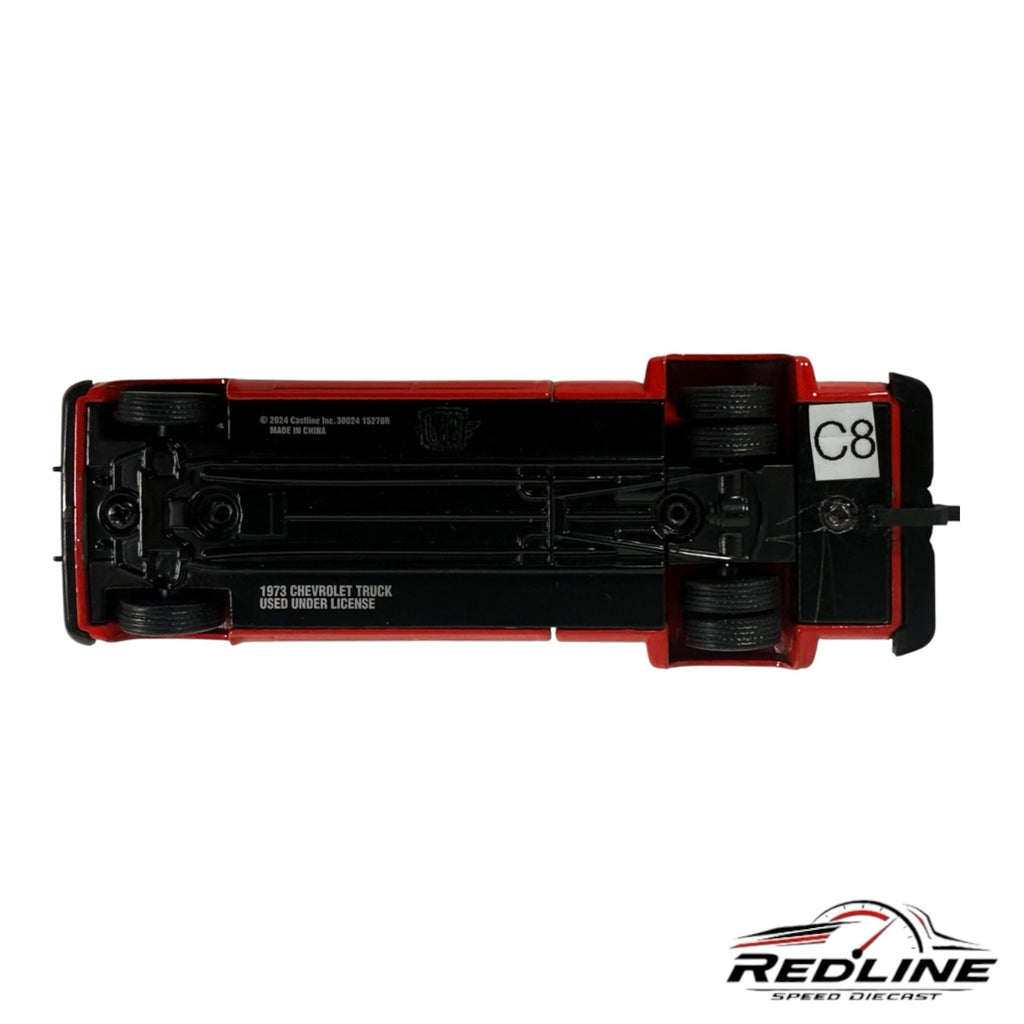 Underside view of a Redline Speed Diecast 1973 Chevrolet crew cab dually pickup truck model showing chassis details.