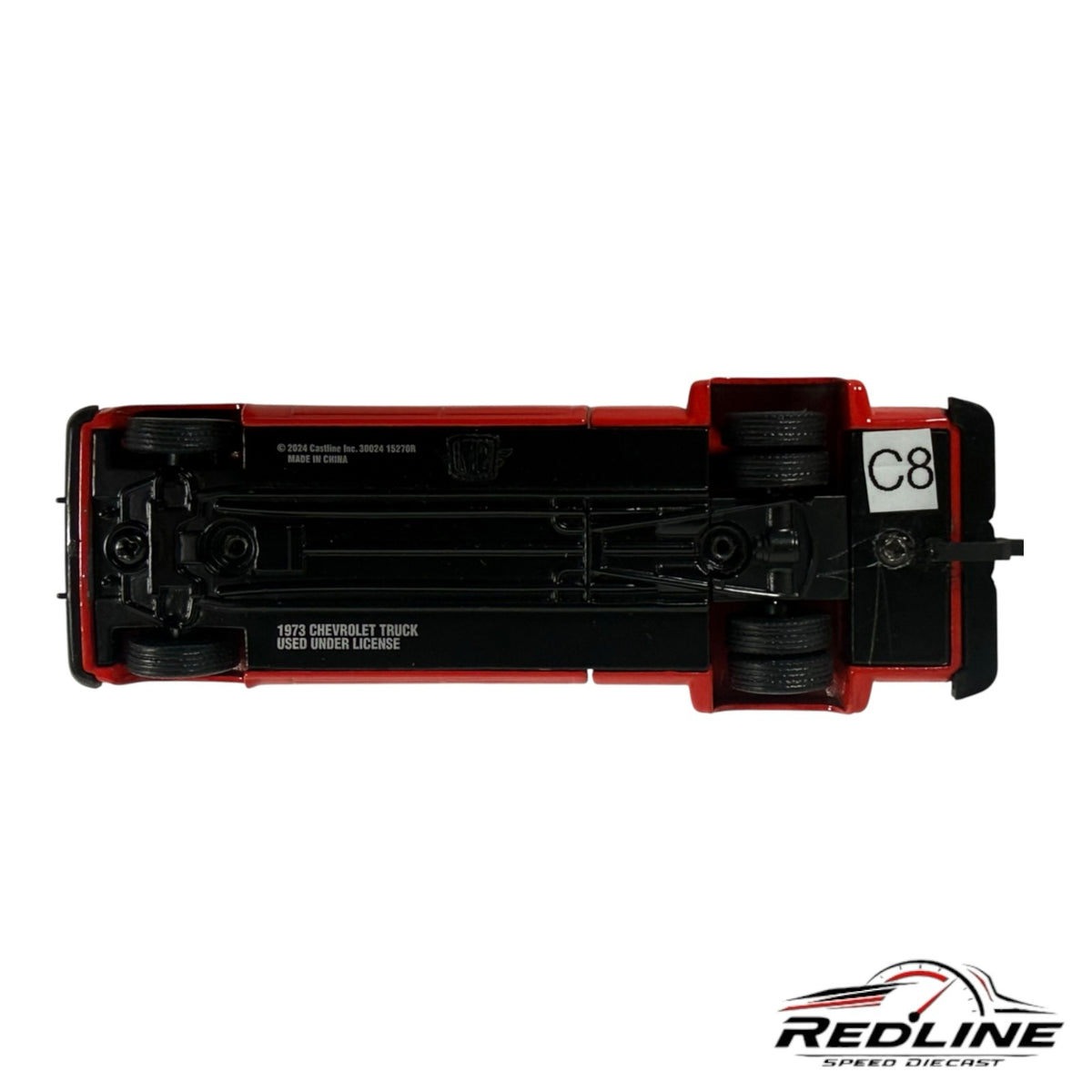 Underside view of a Redline Speed Diecast 1973 Chevrolet crew cab dually pickup truck model showing chassis details.
