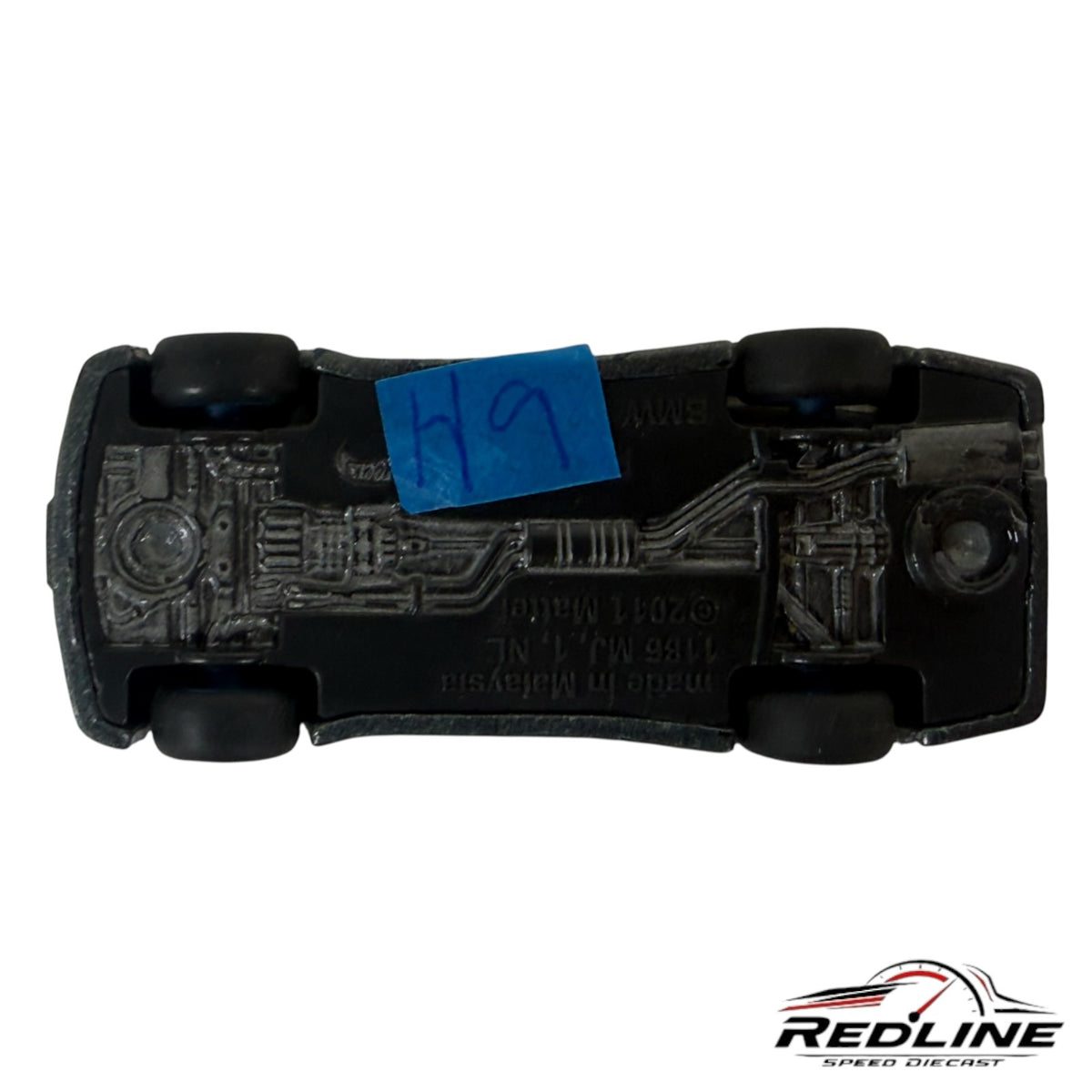 Underside view of a Redline Speed Diecast BMW E30 M3 model car showing the chassis details and black plastic base.