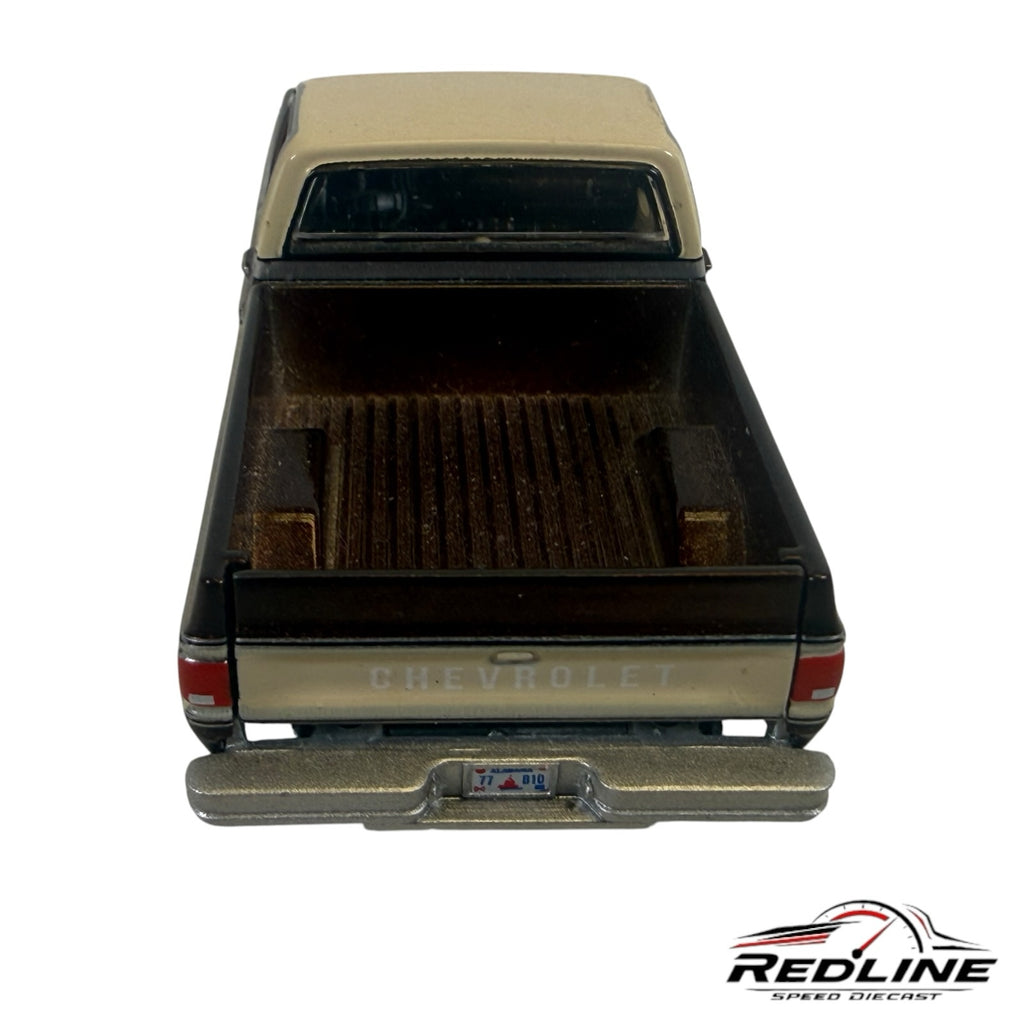 Rear view of a Redline Speed Diecast 1977 Chevrolet C10 pickup truck model in brown and cream with a detailed truck bed