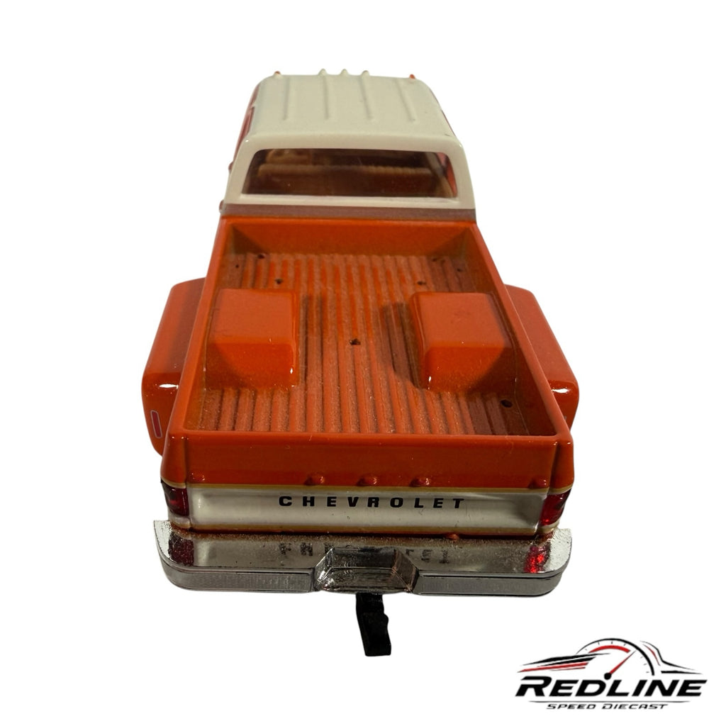 Redline Speed Diecast 1977 Chevrolet C30 dually pickup truck model in orange and white, rear view of truck bed.