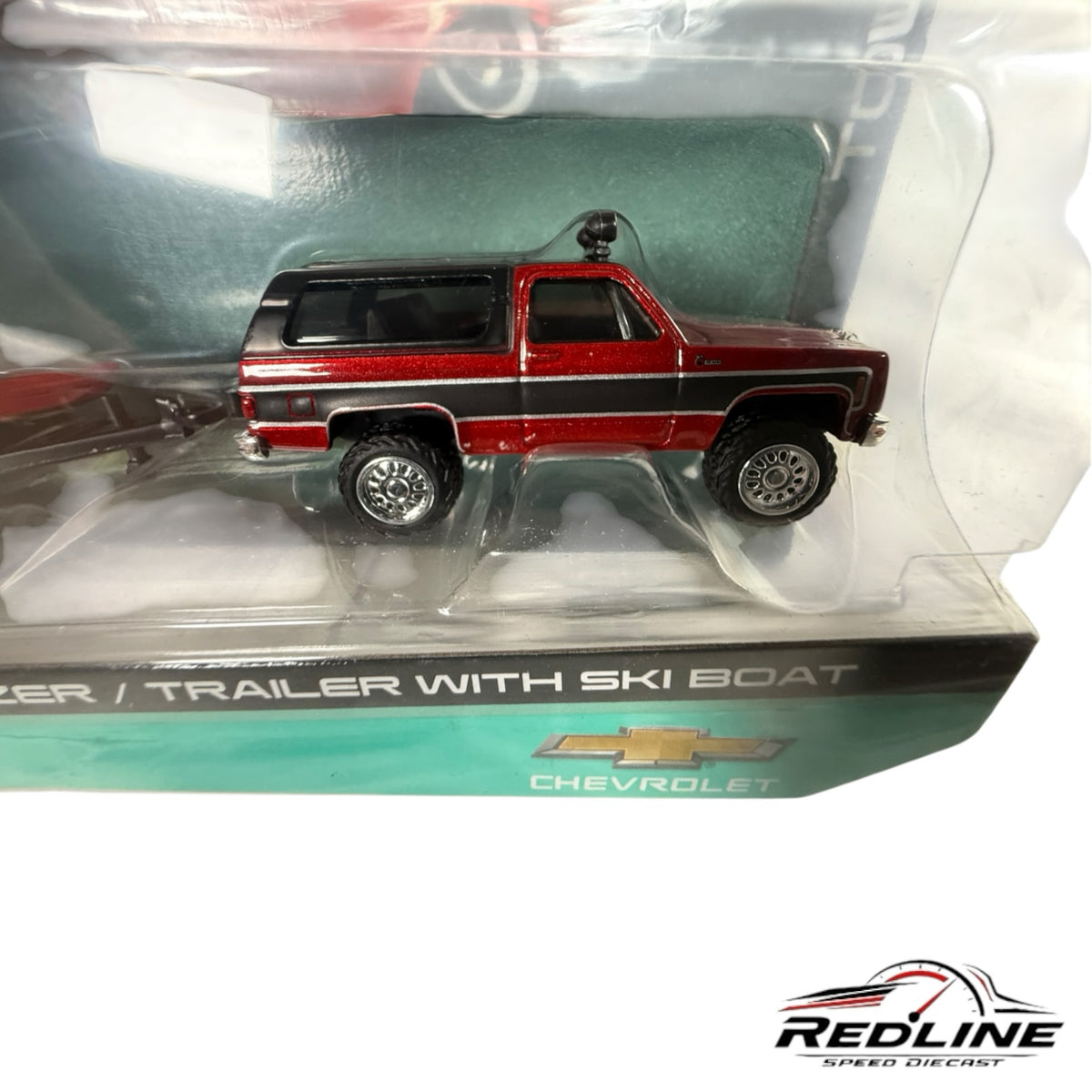 Redline Speed Diecast 1979 Chevrolet K5 Blazer in red and black with a matching ski boat and trailer in packaging.