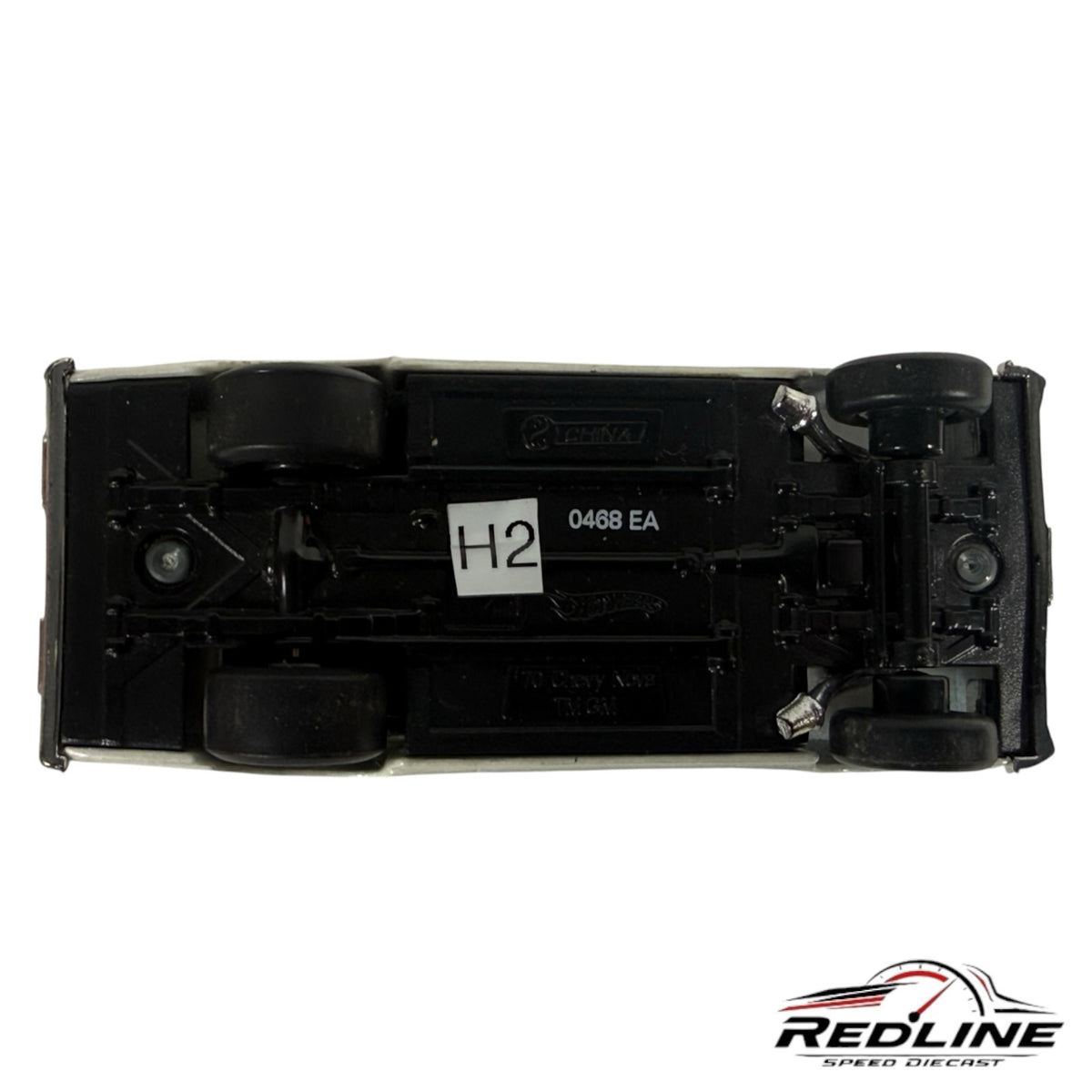 Underside view of a Redline Speed Diecast 1970 Chevrolet Nova model car showing the black chassis and wheels