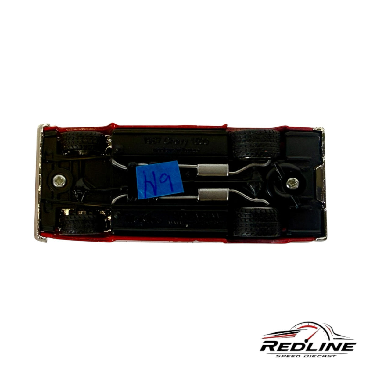 Underside view of a Redline Speed Diecast 1987 Chevrolet Silverado model truck showing chassis and exhaust details.
