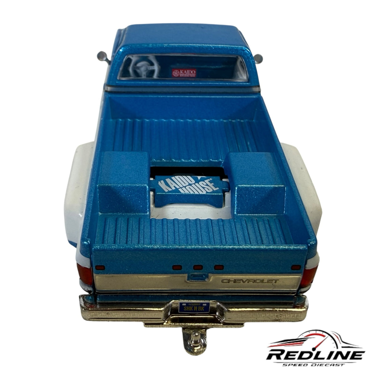 Redline Speed Diecast 1:64 scale blue and white Chevrolet Silverado Dually truck model, rear view with chrome bumper.