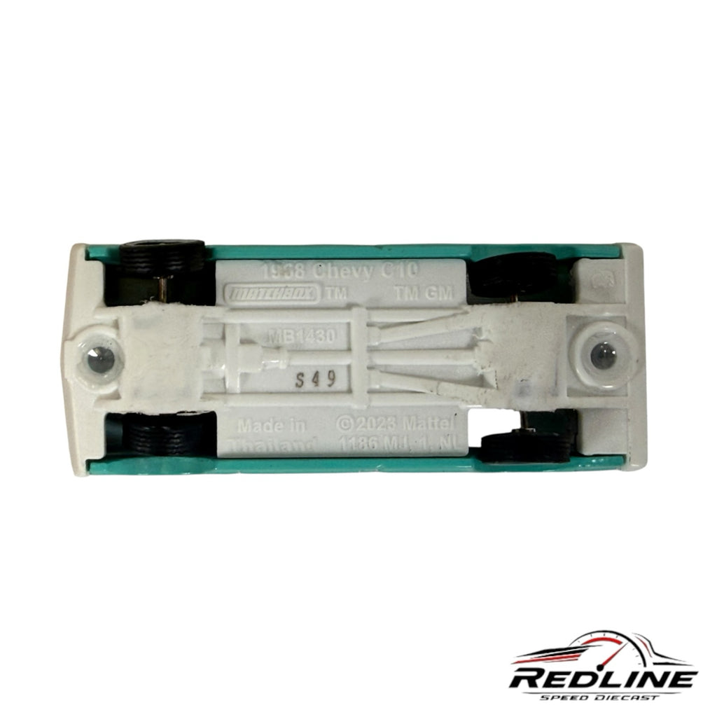 Underside view of a Redline Speed Diecast 1968 Chevy C10 model truck showing the white chassis and black wheels