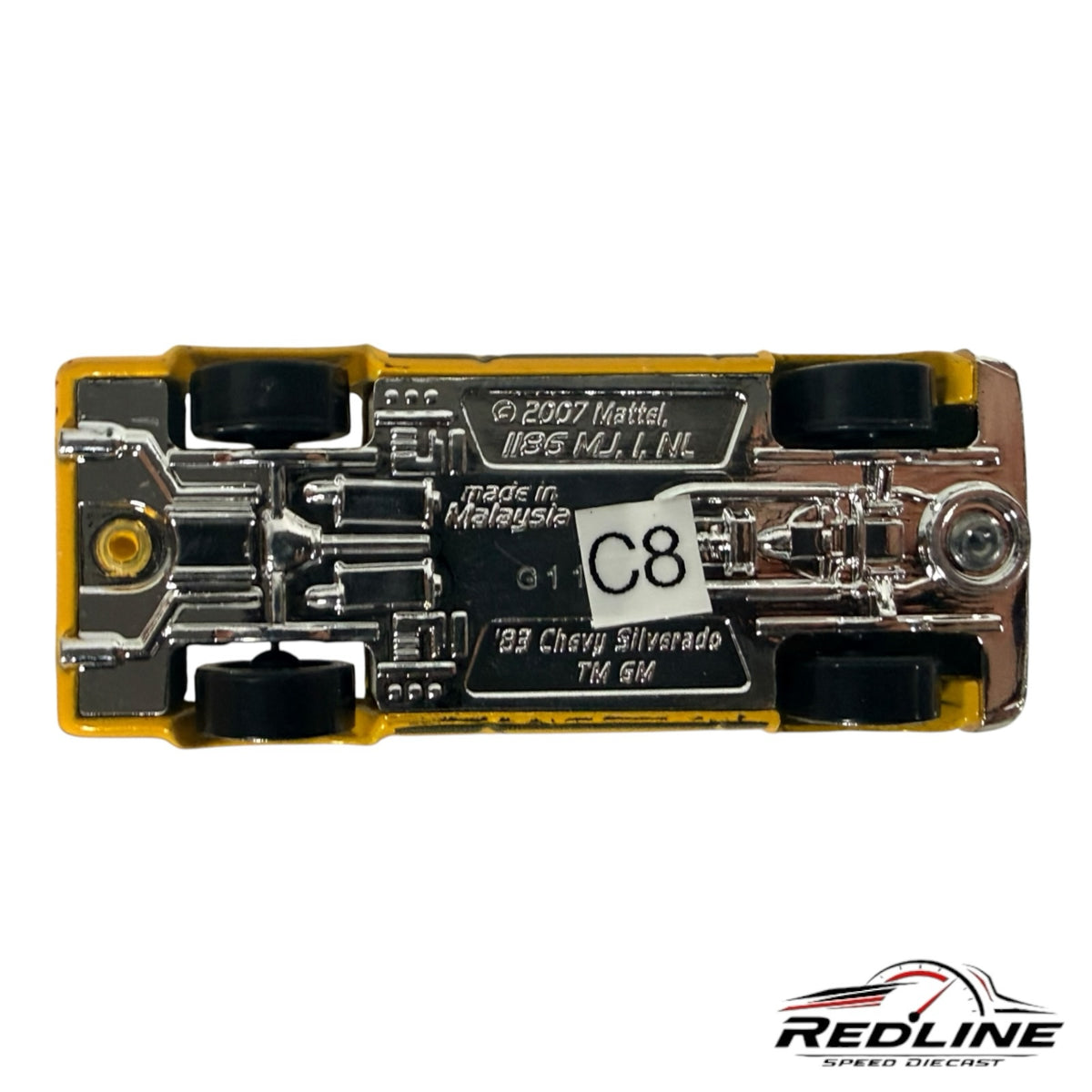 Underside view of a Redline Speed Diecast 1983 Chevy Silverado toy truck showing metal chassis and black wheels