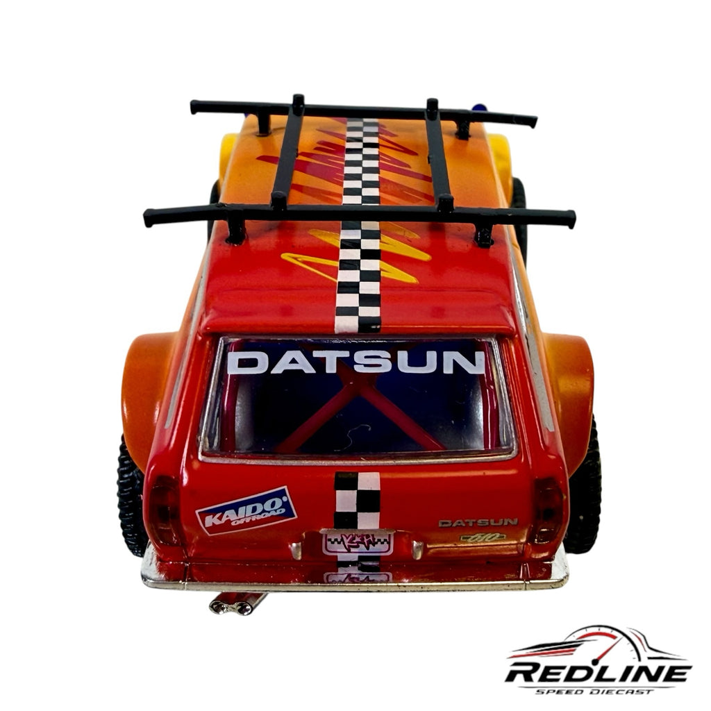 Redline Speed Diecast KAIDO HOUSE Datsun 510 Wagon 4x4 with orange-yellow gradient, roof rack, and checkerboard stripe