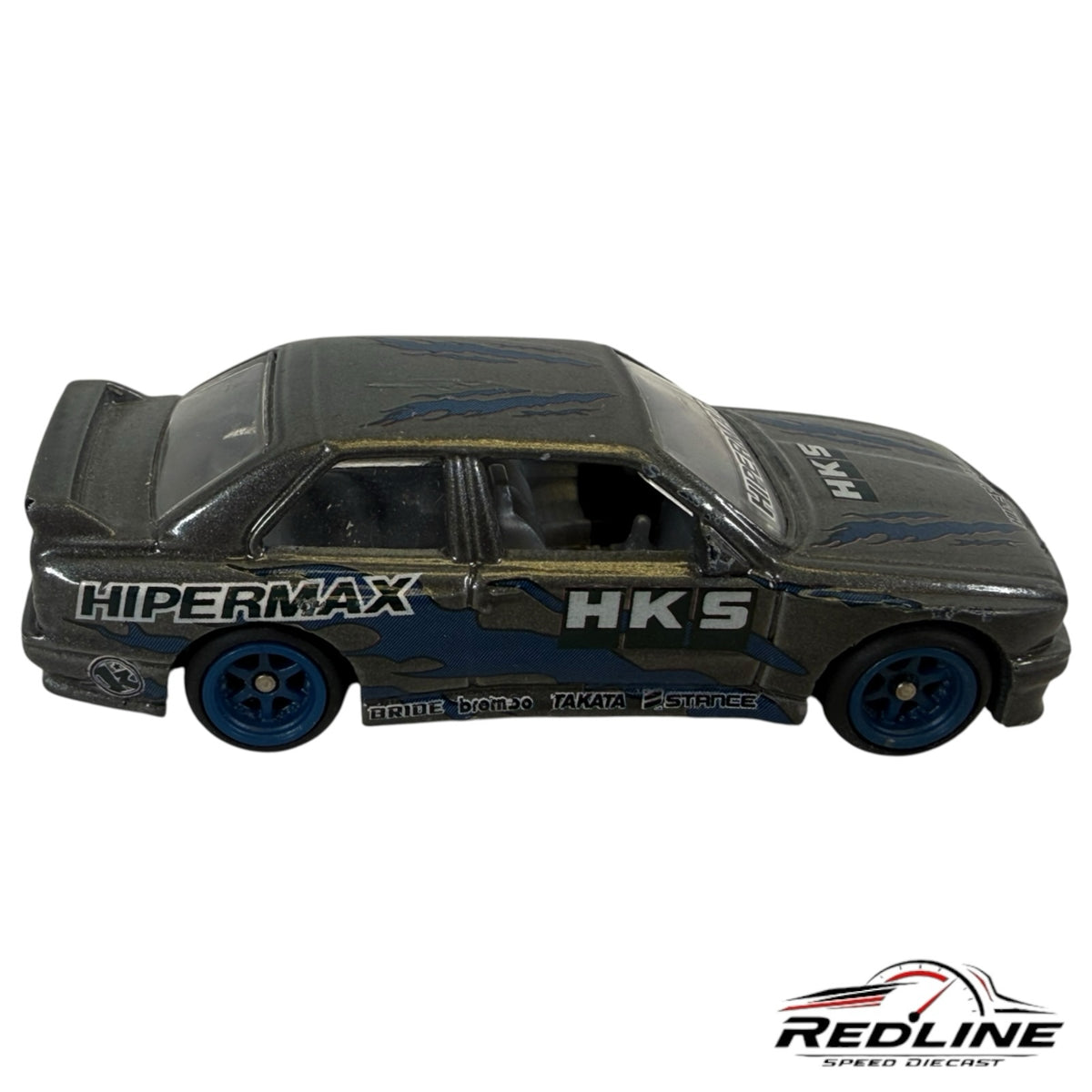 Redline Speed Diecast metallic grey BMW E30 M3 tuner model with blue flame accents, HKS branding, and blue wheels.