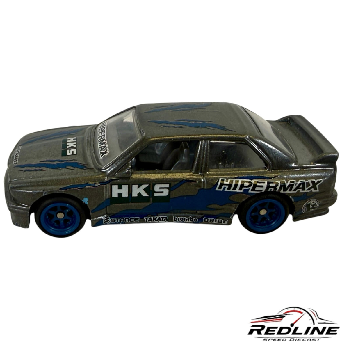 Redline Speed Diecast metallic grey BMW E30 M3 tuner model with blue flame accents, HKS branding, and blue wheels.