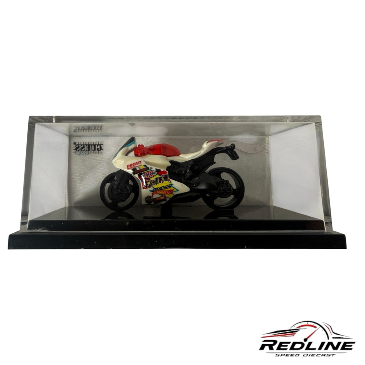 Redline Speed Diecast Hot Wheels GUESS J Balvin Ducati motorcycle model in a clear acrylic display case.
