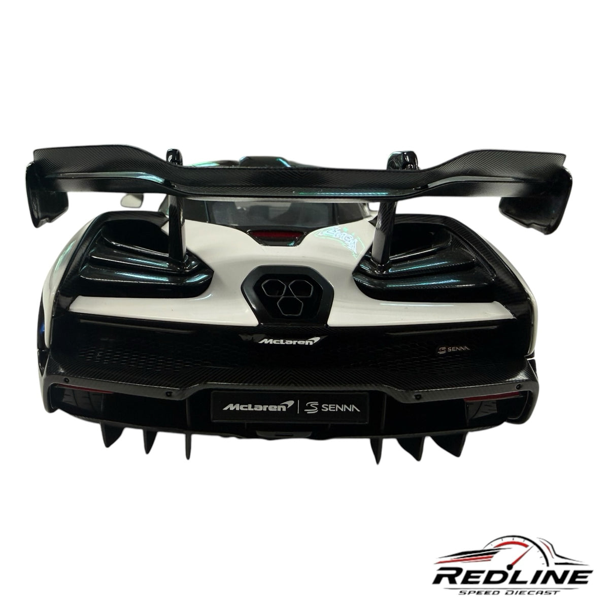 Redline Speed Diecast McLaren Senna model car rear view featuring white bodywork, carbon fiber wing, and diffuser.