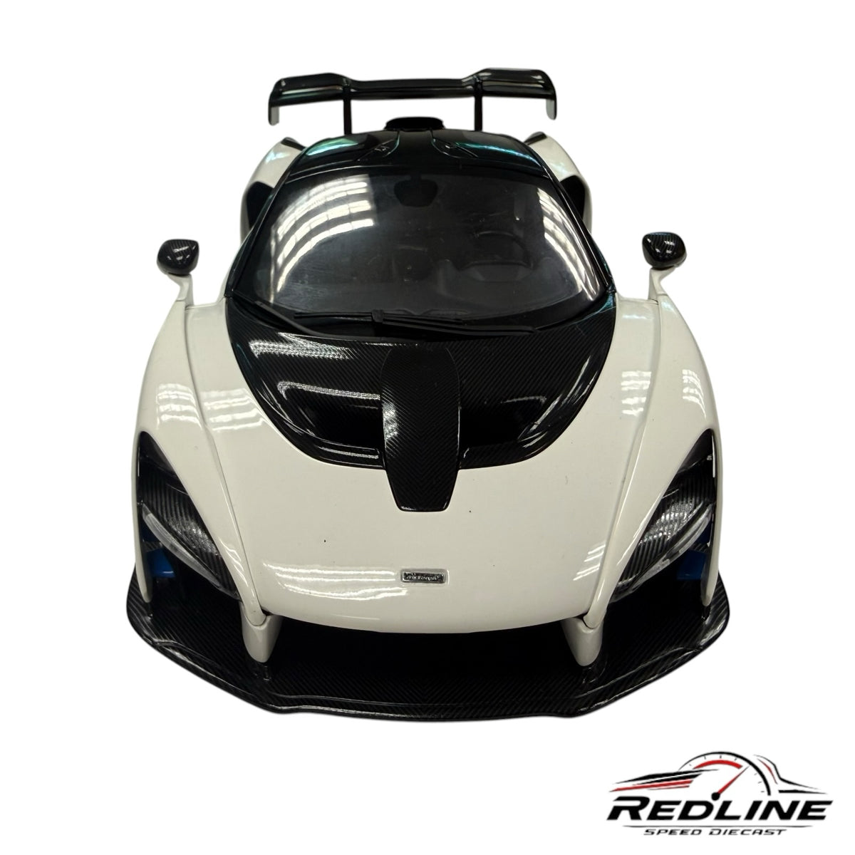 Redline Speed Diecast McLaren Senna model car in white and black with detailed carbon fiber accents, front view.