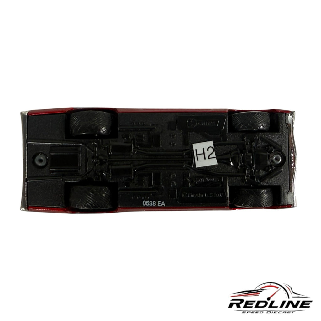 Underside view of a Redline Speed Diecast 1:64 scale red muscle car model showing the black chassis and wheels.