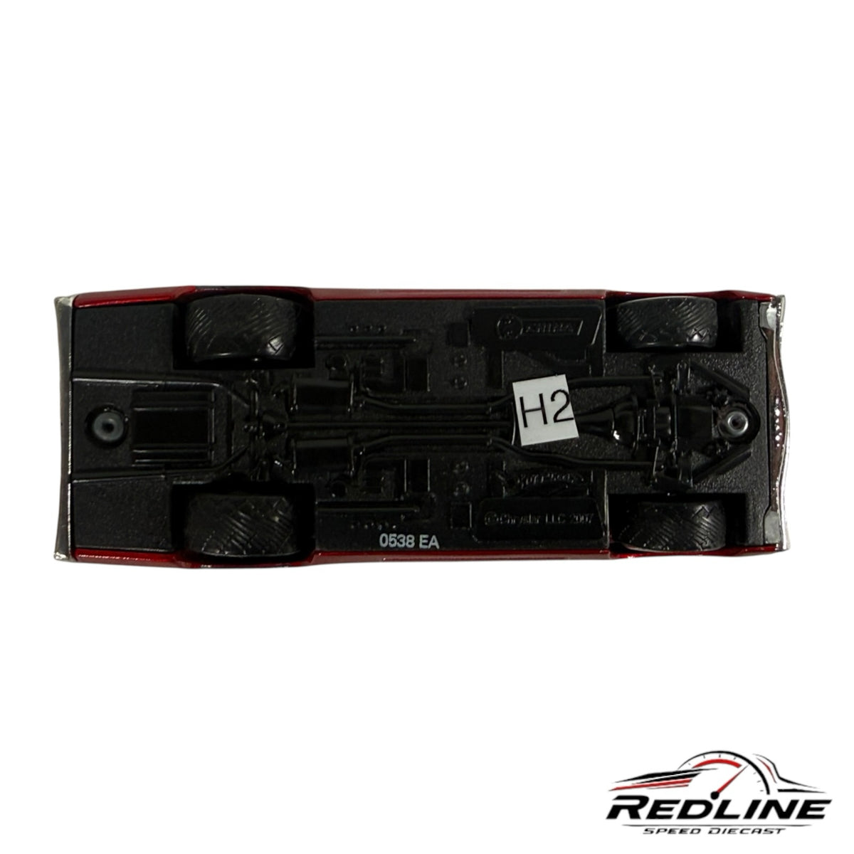 Underside view of a Redline Speed Diecast 1:64 scale red muscle car model showing the black chassis and wheels.