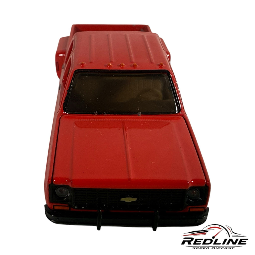 Redline Speed Diecast 1973 Chevrolet crew cab dually pickup truck model in glossy red with a detailed black grille.