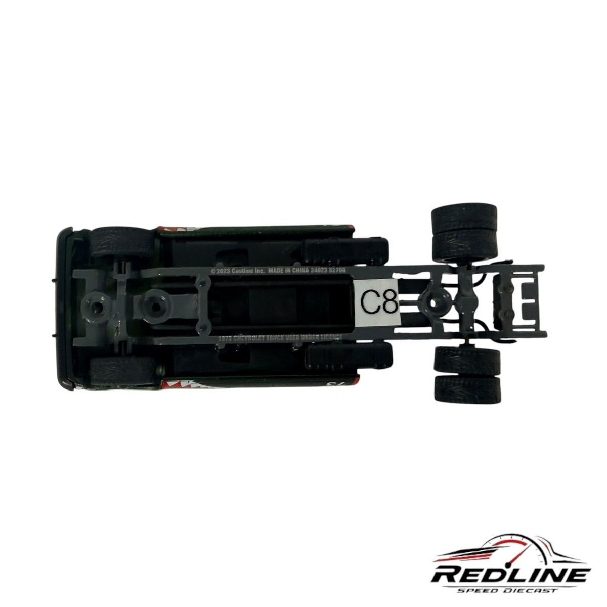 Underside view of a Redline Speed Diecast custom square body pickup truck model showing the dually rear axle chassis.