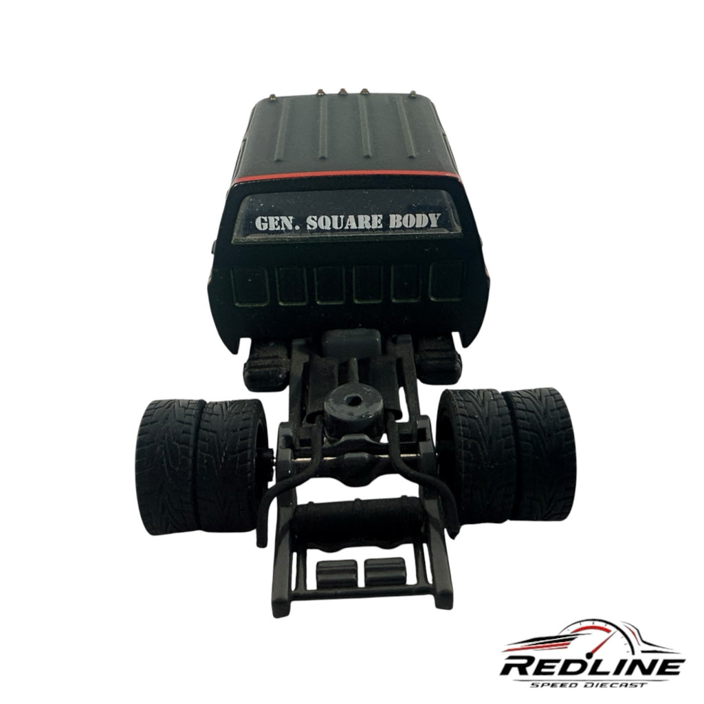 Rear view of a Redline Speed Diecast custom square body pickup truck model with dually rear wheels and black chassis.