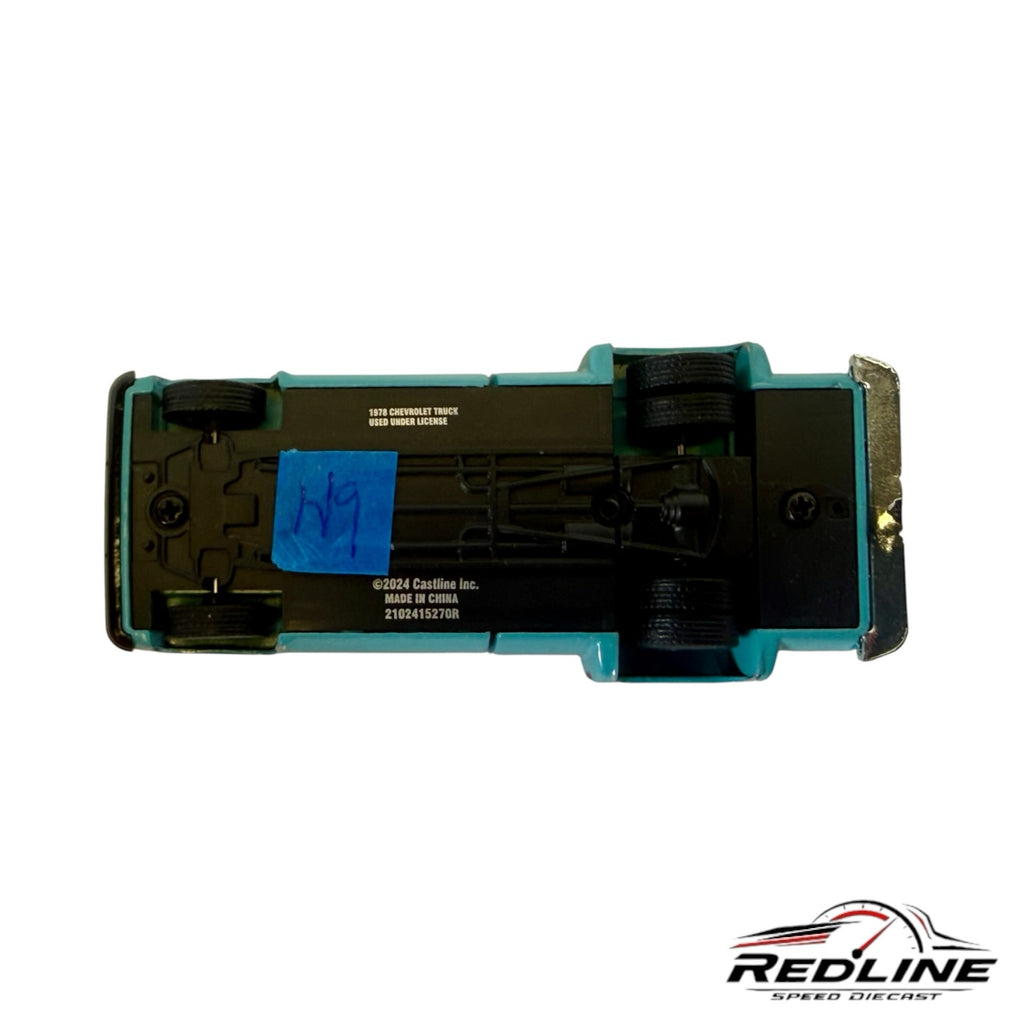Underside view of a Redline Speed Diecast 1978 Chevrolet pickup truck model showing black chassis and tire details.