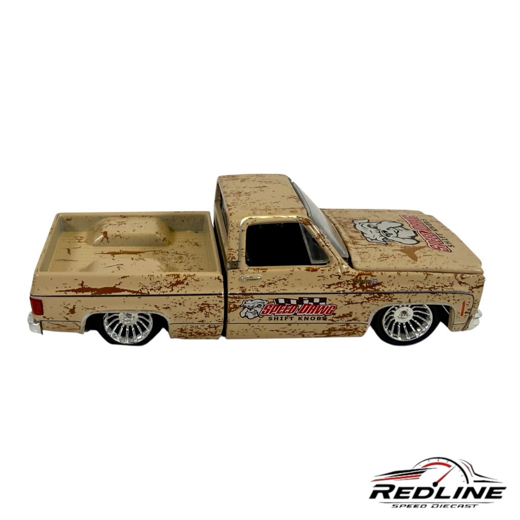 Redline Speed Diecast 1973 Chevrolet pickup truck model with a weathered tan finish, chrome wheels, and custom decals.