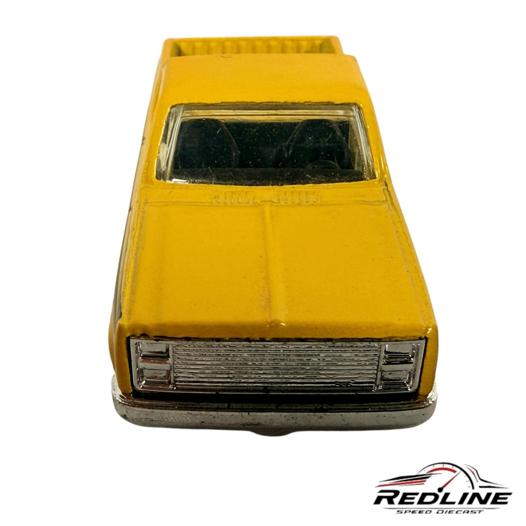 Redline Speed Diecast 1983 Chevy Silverado pickup truck in vibrant yellow with a chrome grille, front view.