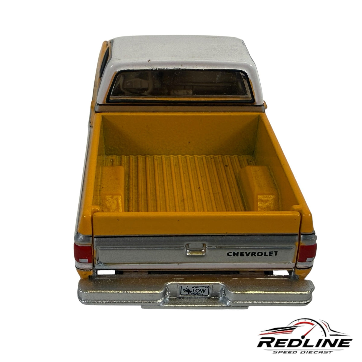 Rear view of a Redline Speed Diecast yellow and white 1970s Chevrolet Cheyenne pickup truck model with chrome bumper.